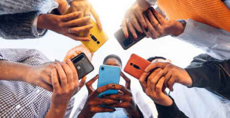 Teens in circle holding smart mobile phones - Multicultural young people using cellphones outside - Teenagers addicted to new technology concept