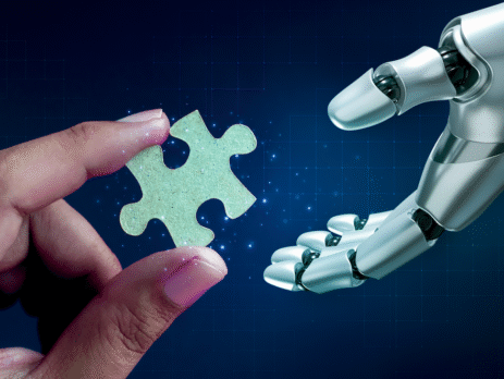 Human hand handing a robot hand a puzzle piece