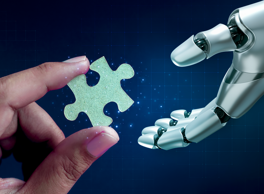 Human hand handing a robot hand a puzzle piece